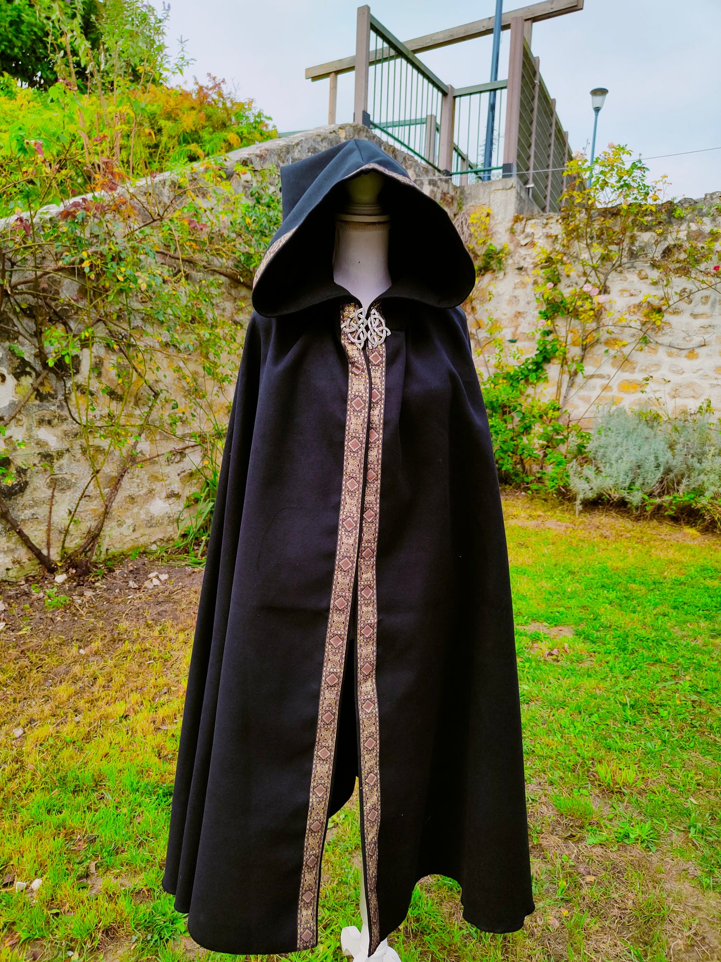 Cape en lainage noir avec capuche pointue et galon marron et doré modèle pour homme ou femme
