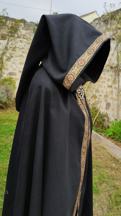 Cape en lainage noir avec capuche pointue et galon marron et doré modèle pour homme ou femme