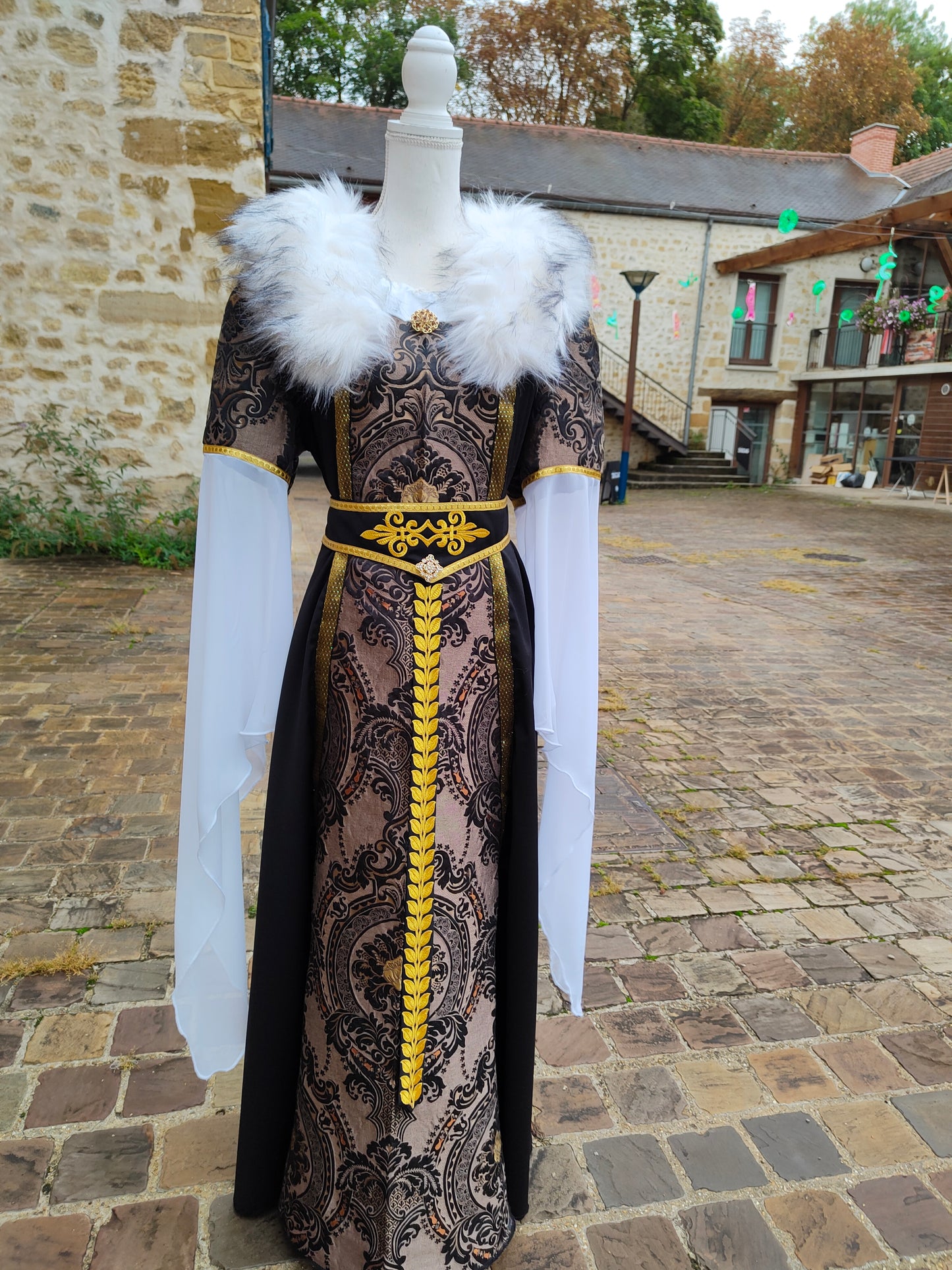 Robe Renaissance ou médiéval tardif pour femme, noire et dorée avec fausse fourrure blanche amovible et ceinture.